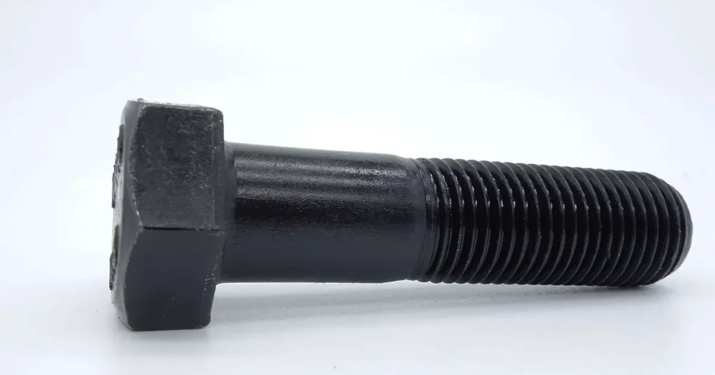 Black oxide finished steel hex head bolt with partial thread on white background