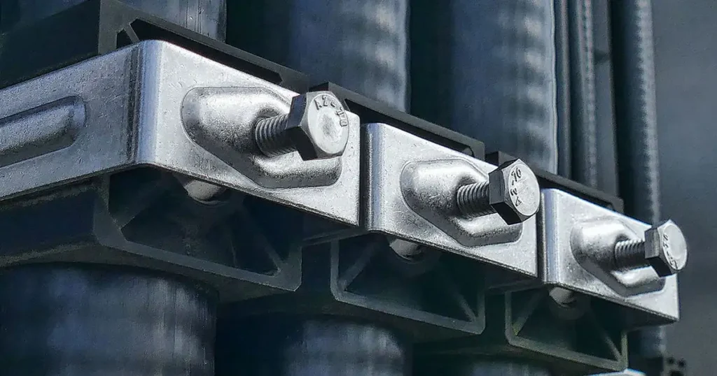 Stainless steel hex bolts securing heavy duty cable clamps in electrical installation