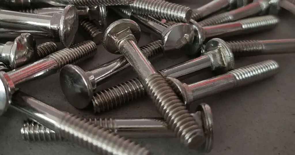 Bulk pile of shiny zinc plated carriage bolts for woodworking and structural fastening