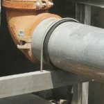 Stainless steel U bolt securing industrial pipeline and support structure