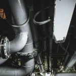 Stainless steel u bolt clamp securing heavy duty metal pipes in industrial ceiling framework