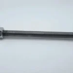 A single, elongated galvanized metal carriage bolt with a round head, a square neck, and a mostly threaded shank, positioned horizontally against a plain white studio background. A single hexagonal nut is threaded partially onto the shank, showing the contrasting light-colored metal of the nut against the dark grey bolt.
