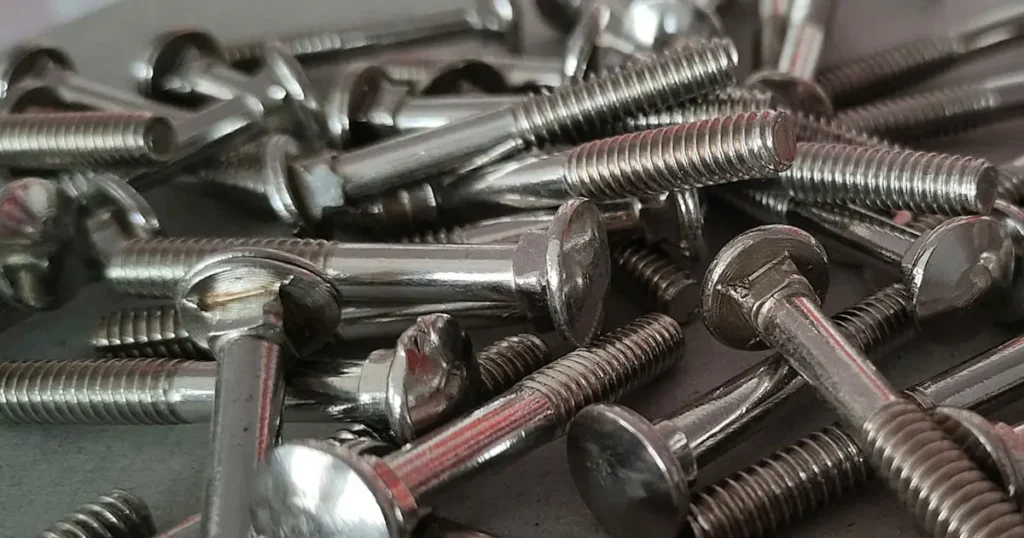 Pile of zinc plated stainless steel carriage bolts showing round heads and square necks