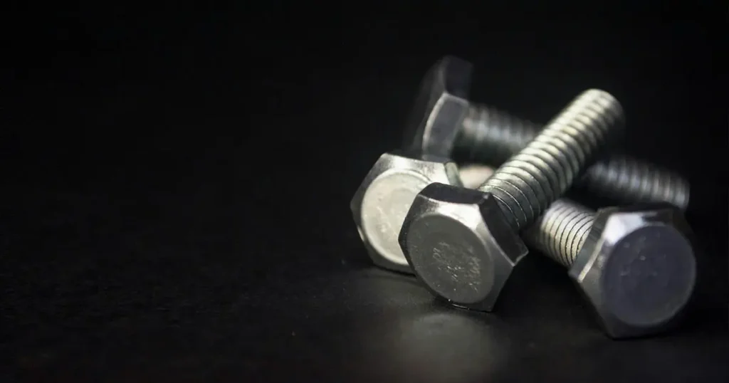 Zinc plated steel hex head bolts on black background for machinery assembly